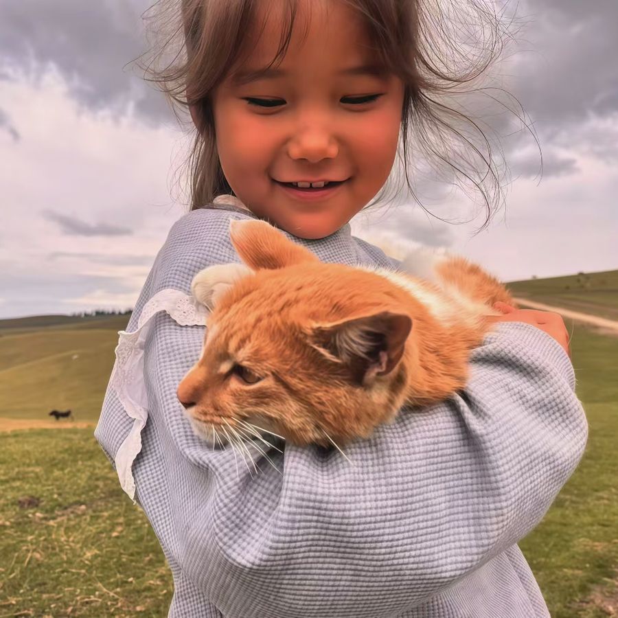 小女孩抱着橘猫,笑得眯起眼