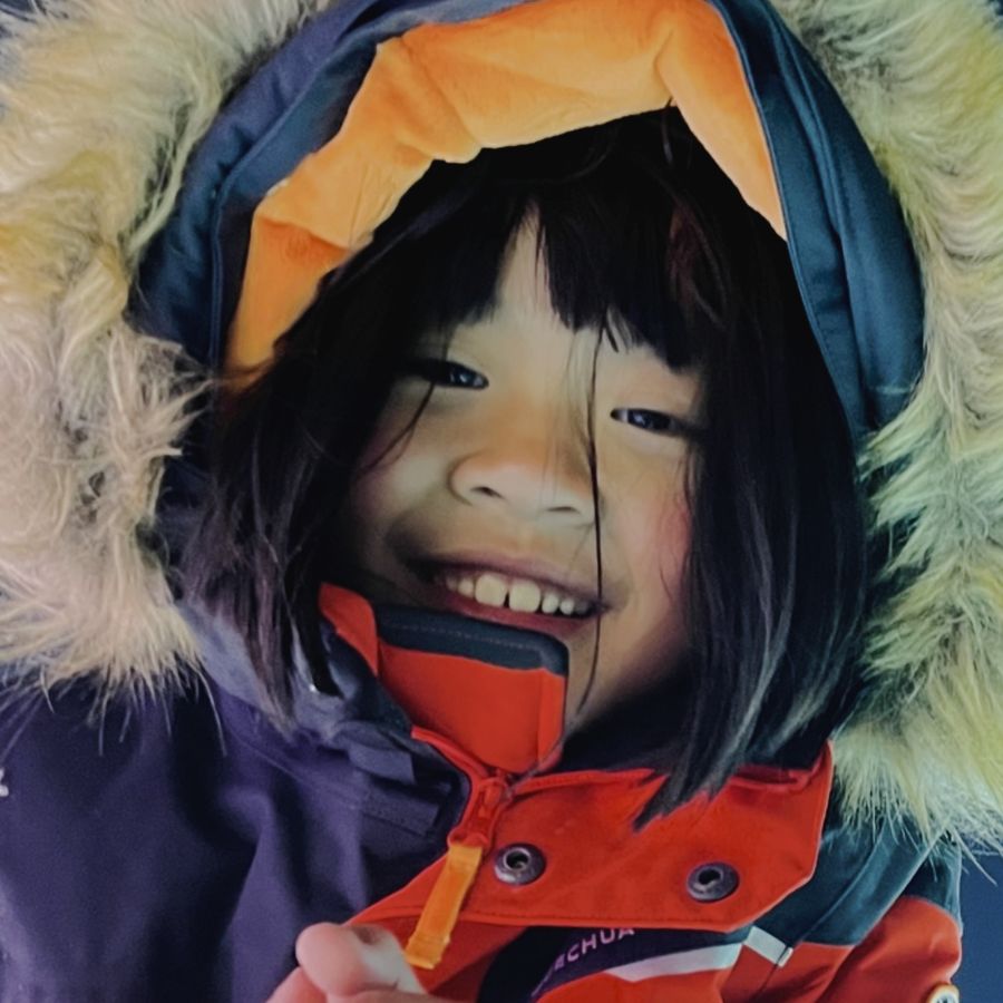 冰灯前裹着毛领帽子笑的小姑娘