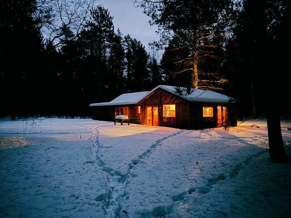 雪夜里窗灯暖黄的小木屋,雪地上留着脚印